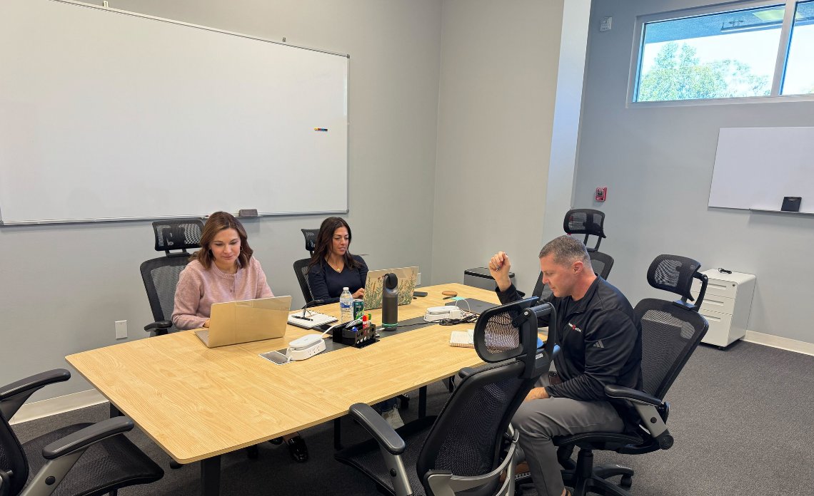 BuyerBridge team members working in the office conference room