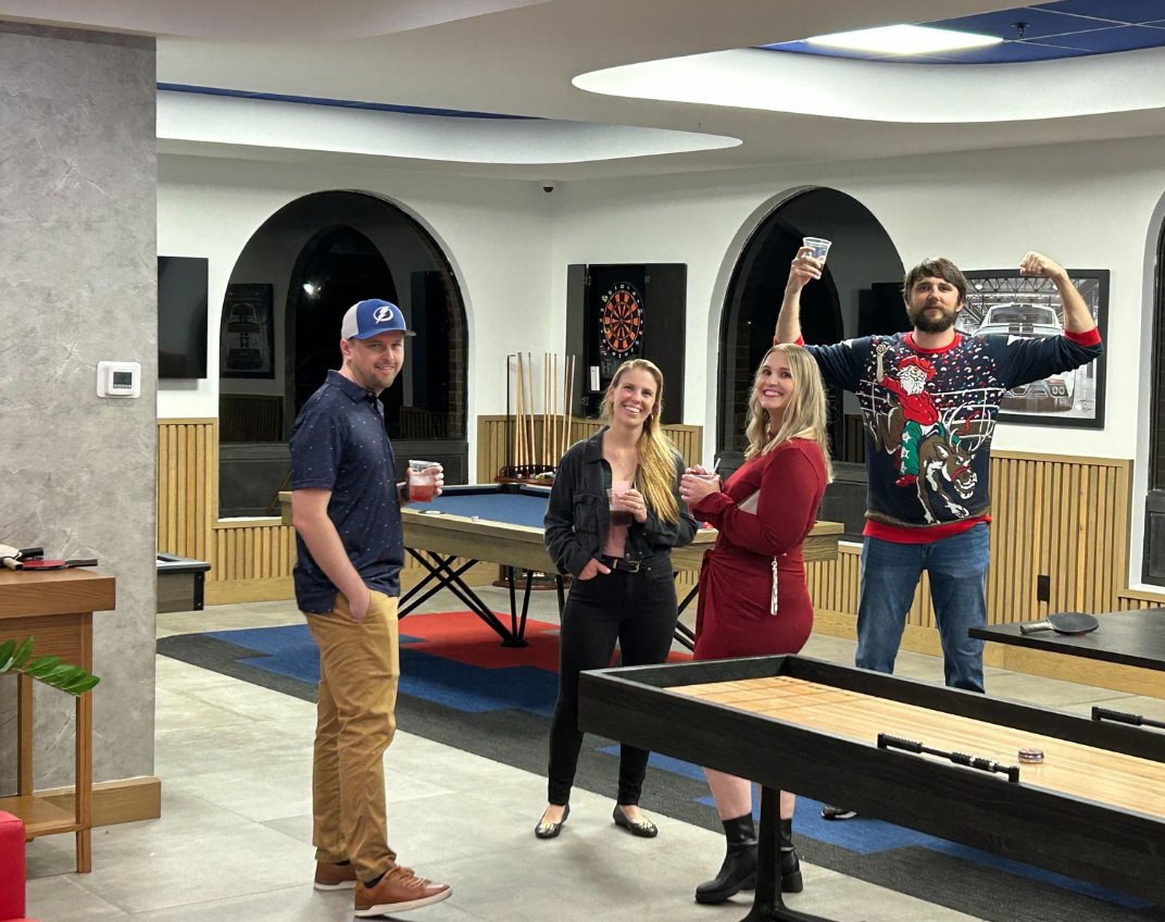 BuyerBridge team members celebrating in the office game room